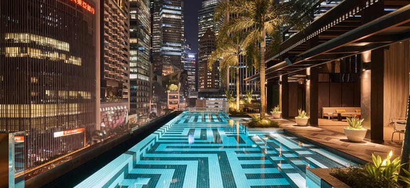 Rooftop Bar in QT Singapore with stunning nighttime pool and vibrant city skyline.