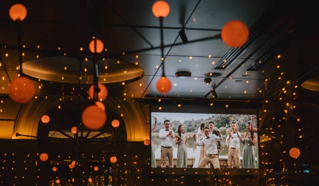 Warm ambient lighting at an indoor-outdoor wedding reception featuring glowing globe pendants.