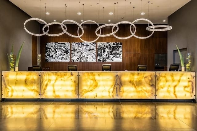 Modern InterContinental Warsaw reception with illuminated onyx desk for corporate events.
