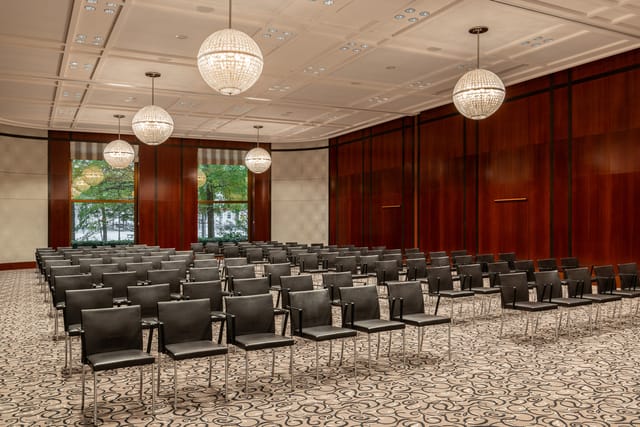 The Charles Hotel Ballroom in Munich, featuring sleek black chairs for professional conferences.
