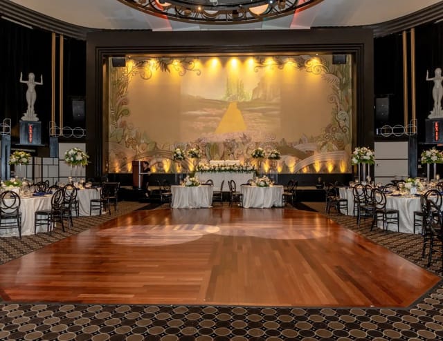 Eglinton Grand ballroom gala with hardwood dance floor and stage lighting for corporate event venue.