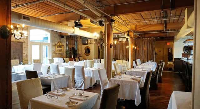 Industrial-chic banquet hall with exposed beams, ideal for formal wedding or corporate event.