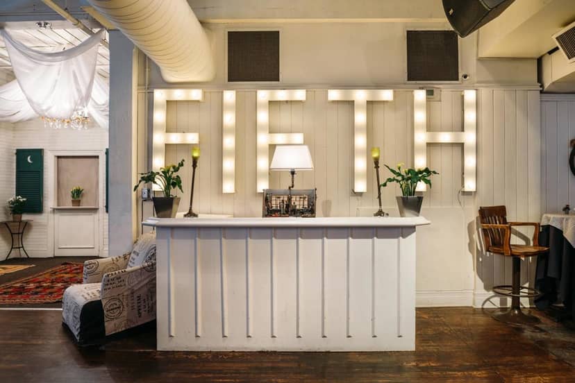 The Fifth Social Club event check-in desk with marquee lighting for corporate events and galas.