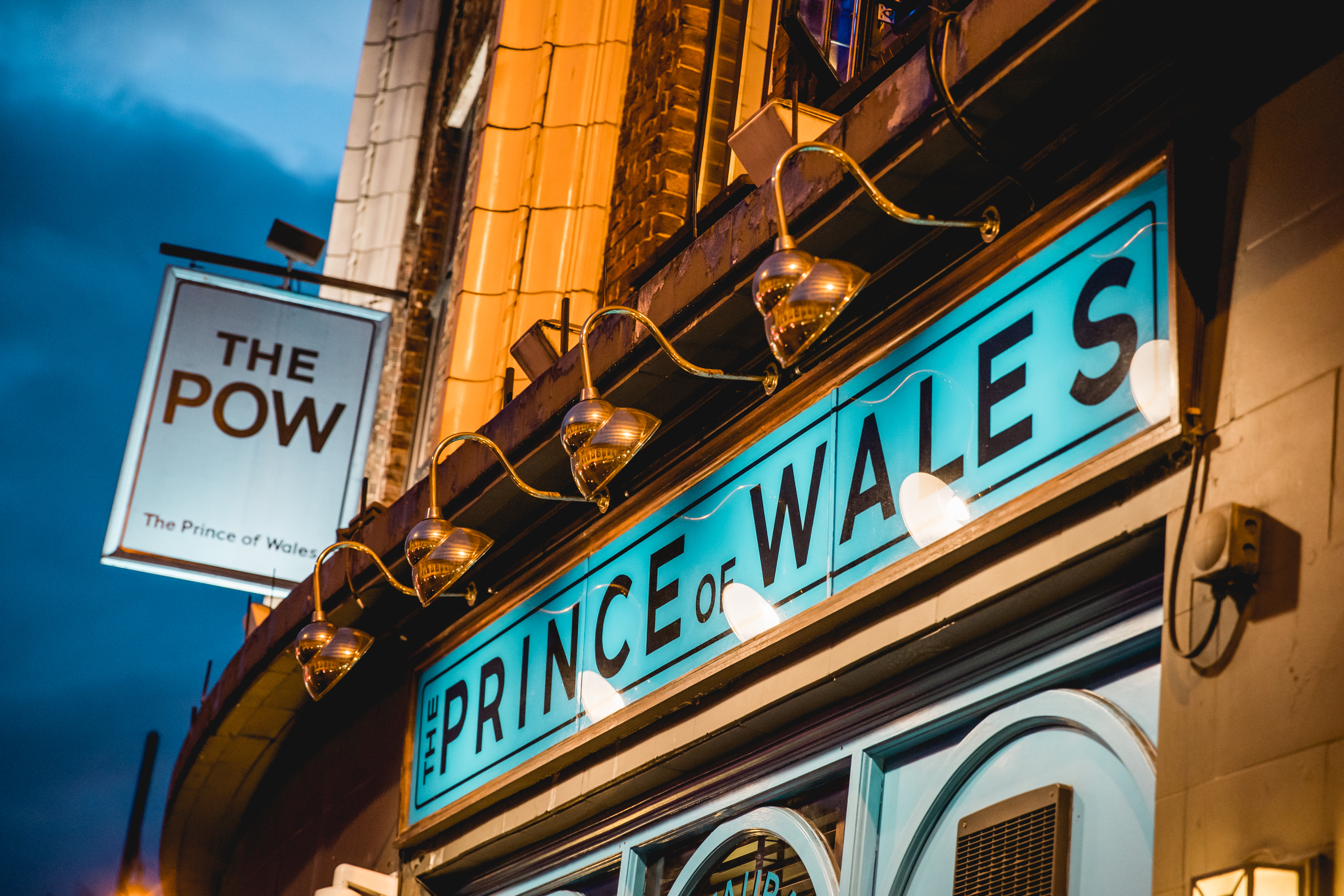 The Prince of Wales Pub in Brixton: vibrant venue for events, warm lighting atmosphere. - Banner