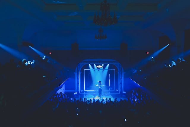 Geometric stage at The Great Hall with dramatic downlighting for keynote event and live music.