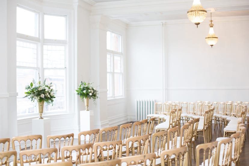 Minimalist Great Hall ceremony room with gold Chiavari chairs for luxury wedding events.