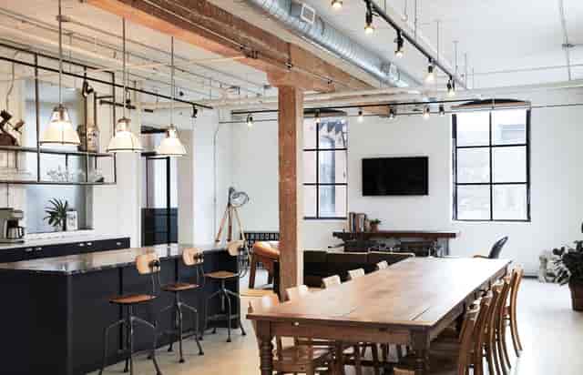 Industrial-chic East Room event venue with kitchen island for workshops and corporate dinners.