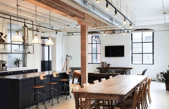 Industrial-chic East Room event venue with kitchen island for workshops and corporate dinners.