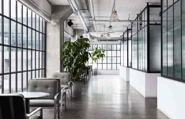 Industrial-chic East Room social club with natural light for corporate retreats and networking.