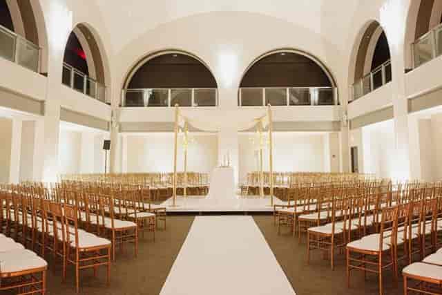 Arcadian Loft wedding ceremony with arched windows and symmetrical venue decor.
