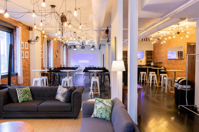 Industrial-chic meeting room with lounge area for corporate workshops and networking events.