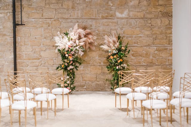 Foxwarren Room rustic stone wall ceremony setup for high-end wedding and event venue.