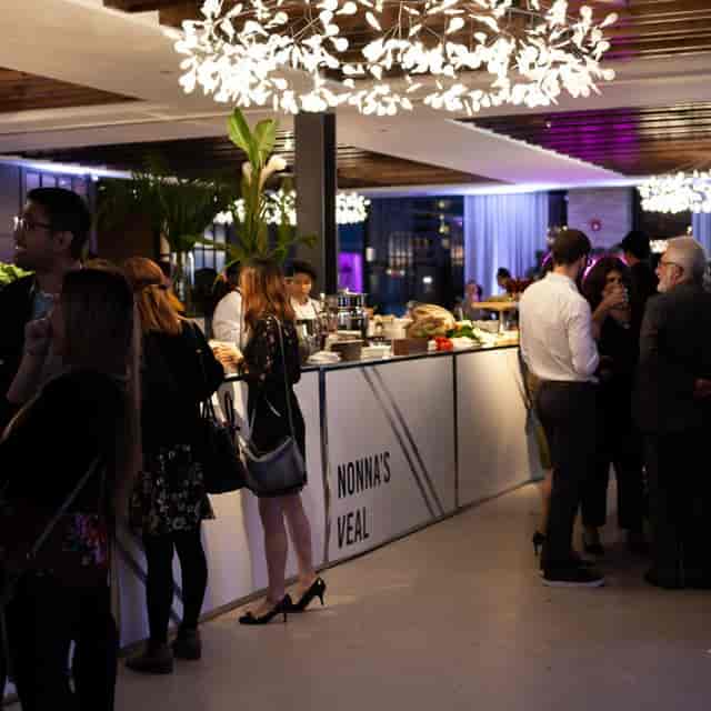 Corporate networking reception featuring a branded satellite bar at Village Loft event space.