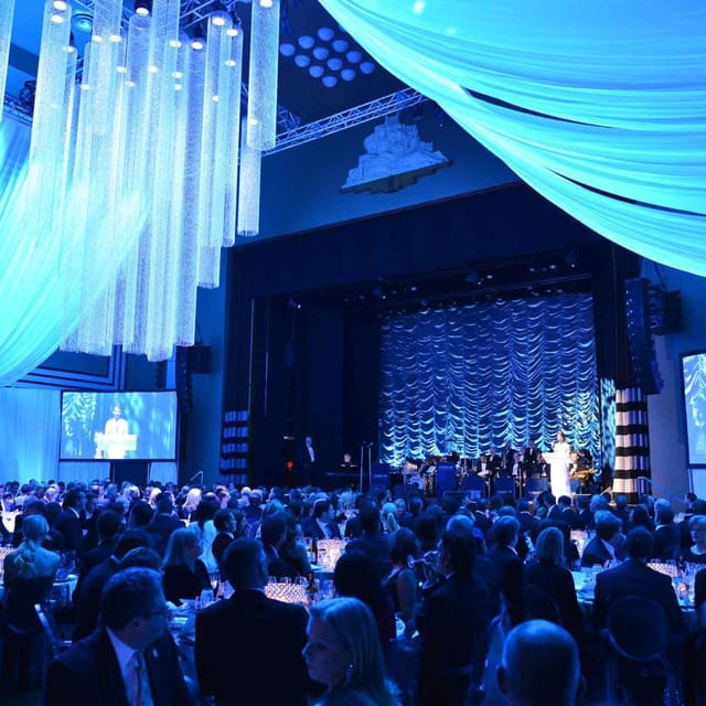 Carlu Ballroom event with blue atmospheric lighting and stage screens for corporate gala or wedding.
