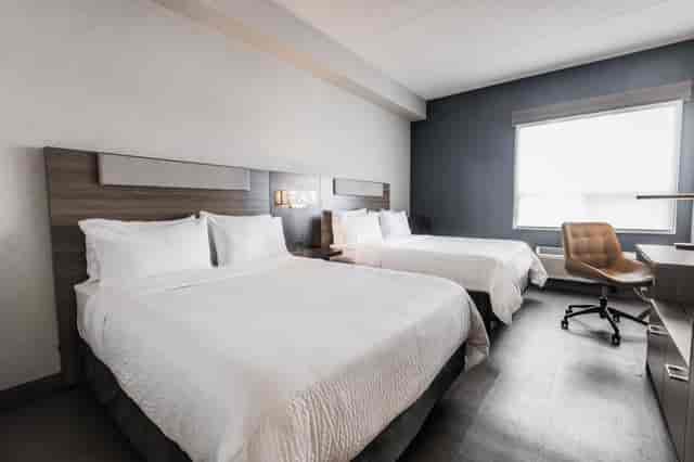 Modern double-queen guest room for corporate conferences and professional events.
