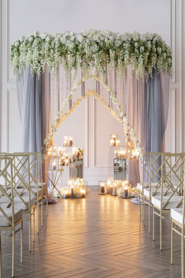 Heritage House wedding ceremony with floral arch and candles for romantic event styling.