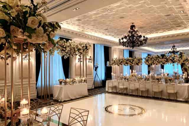 Luxury wedding ballroom at St. Regis Toronto with gold floral centerpieces and white dance floor.