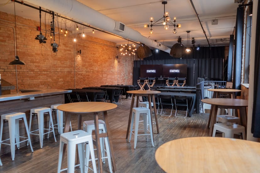 Industrial-chic breakout room with stage, ideal for corporate offsite meetings and networking.