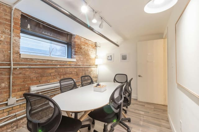 Industrial-chic breakout room with elliptical table for corporate offsite and team workshop.