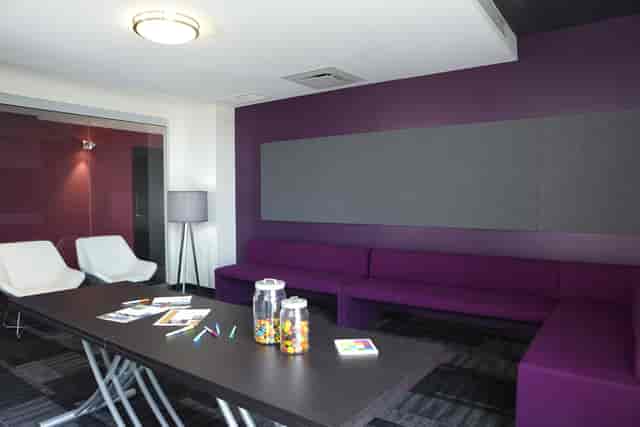 Modern breakout room with purple modular seating for collaborative corporate meetings.