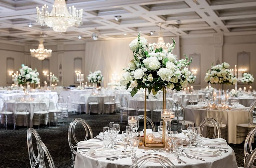 Ballroom wedding venue at TCE on Sterling with elegant centerpieces and acrylic ghost chairs.