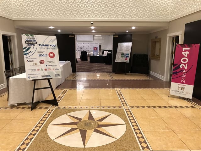 Corporate event registration area at The Terrace Banquet Centre with open floor plan and signage.