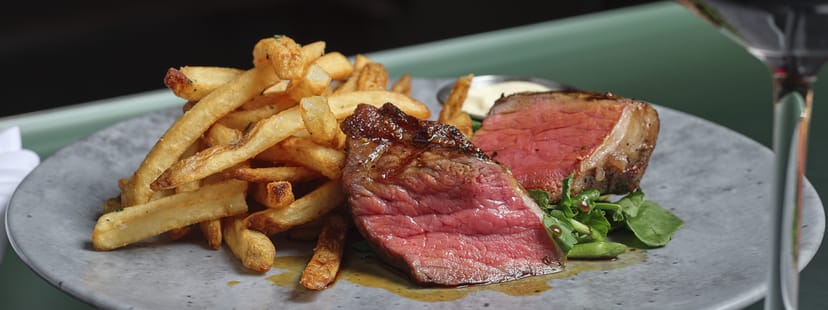 Steak frites entrée at AGO Bistro, perfect for corporate banquet catering and event menus.