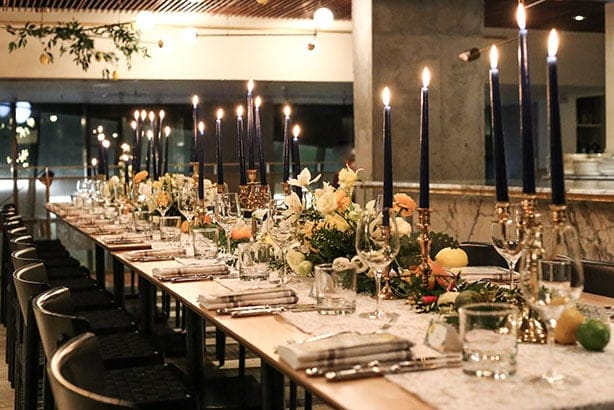 Long-table dinner setup at Oretta Midtown Mezzanine with taper candles for gala corporate events.