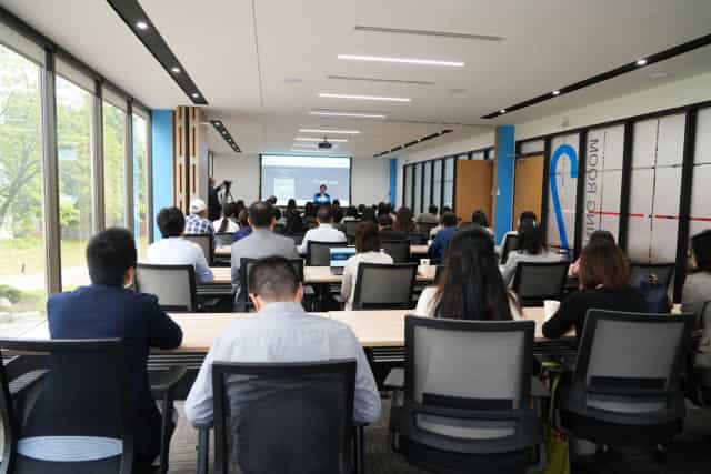 Classroom-style S³PACE event venue with high-density seating and natural light for conferences.