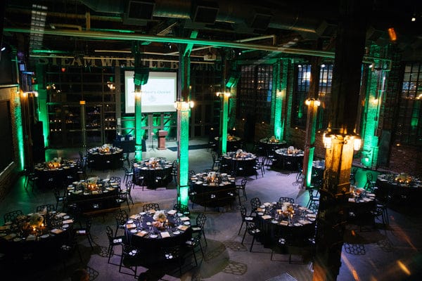 Pilsner Hall gala with green uplighting: industrial chic event venue and banquet space.