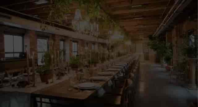 Baro industrial-chic banquet table with warm lighting for corporate events or wedding receptions.