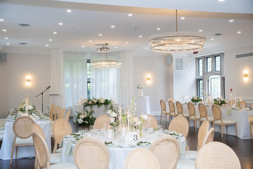 Elegant ballroom wedding reception at Estates of Sunnybrook with sophisticated floral centerpieces.