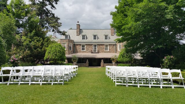 Outdoor wedding ceremony at historic Estates of Sunnybrook with aligned guest seating.