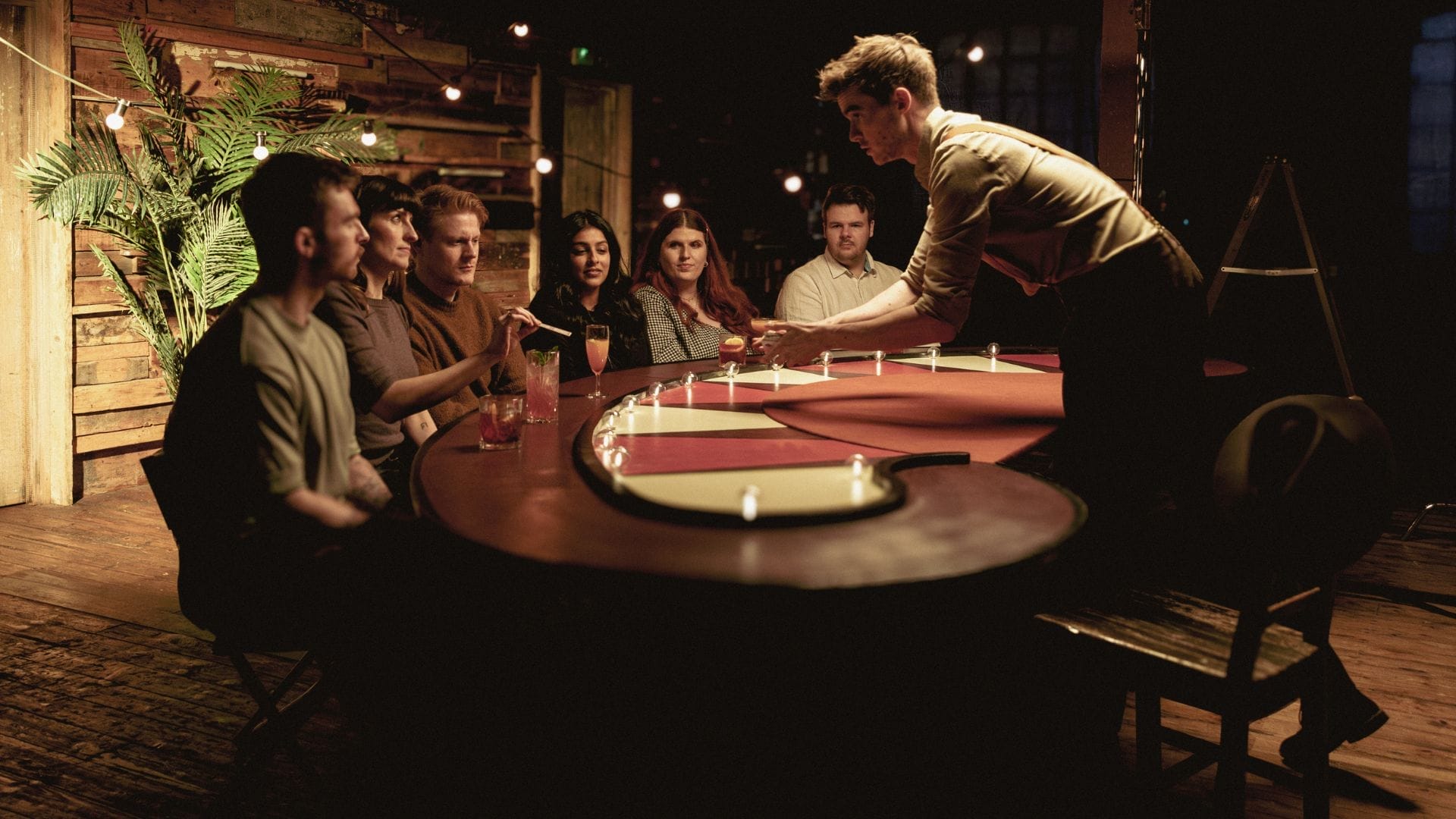 Team-building event at The Magicians Table with ambient lighting and rustic setting. - Banner