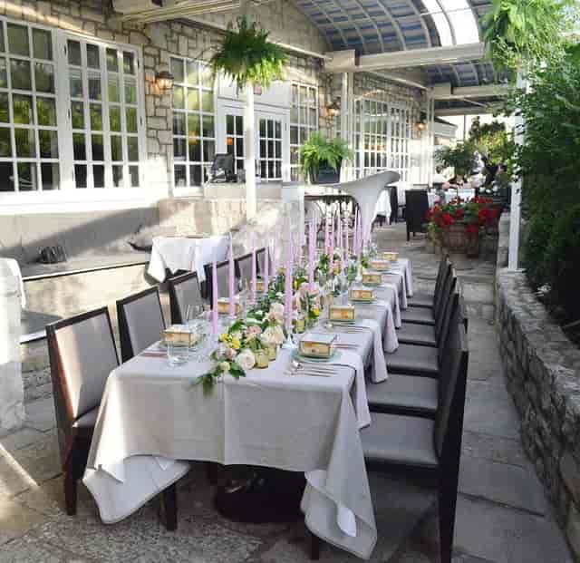 Elegant outdoor banquet setup on stone patio for private dining events and luxury wedding receptions.