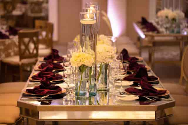 Elegant gala tablescape with burgundy linens and floral decor for luxury wedding events.