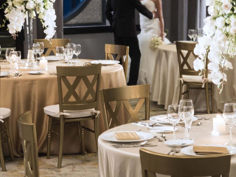 Elegant wedding reception at Marquis Reforma with gold cross-back chairs and orchid centerpieces.