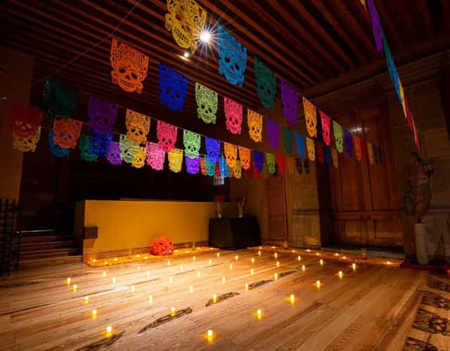 Dia de los Muertos event at Club de Banqueros with papel picado and candlelit decor.