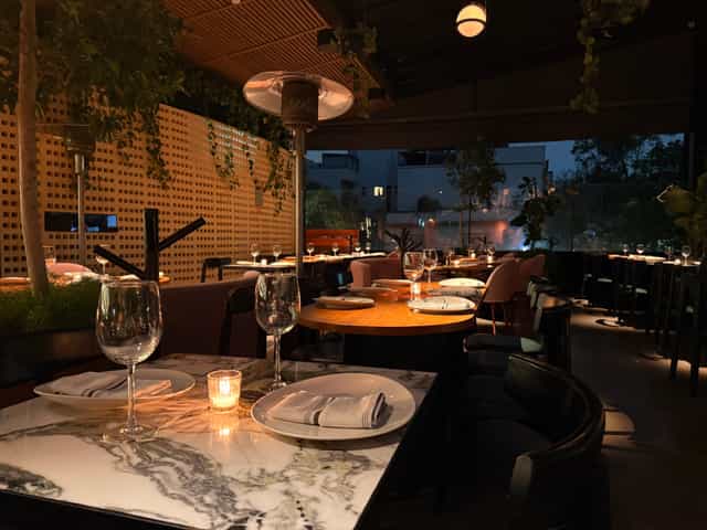Upscale rooftop reception at Balmori Roma with ambient lighting and greenery for private events.