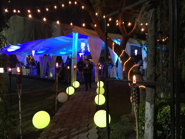Quinta las Águilas outdoor event hall with blue uplighting, garden party, and wedding venue decor.