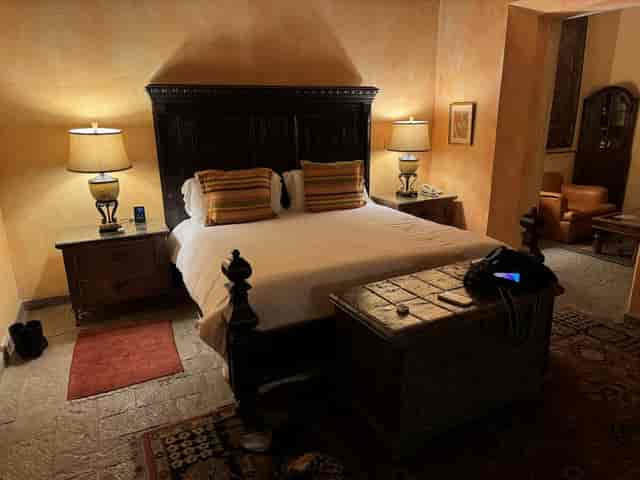 Luxury villa guest suite with ornate wooden bed for boutique hotel and wedding accommodations.