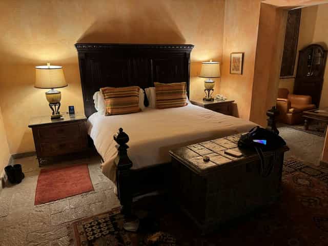 Luxury villa guest suite with ornate wooden bed for boutique hotel and wedding accommodations.