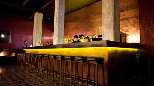 Industrial-chic bar venue with backlit pillars for high-end evening reception and networking events.