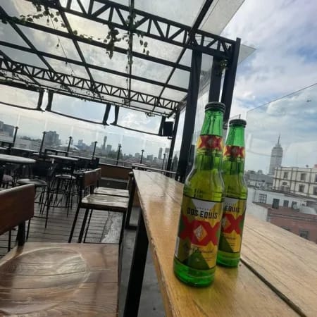 Rooftop networking mixer at Terraza Dos Equis with high-top seating and city views.