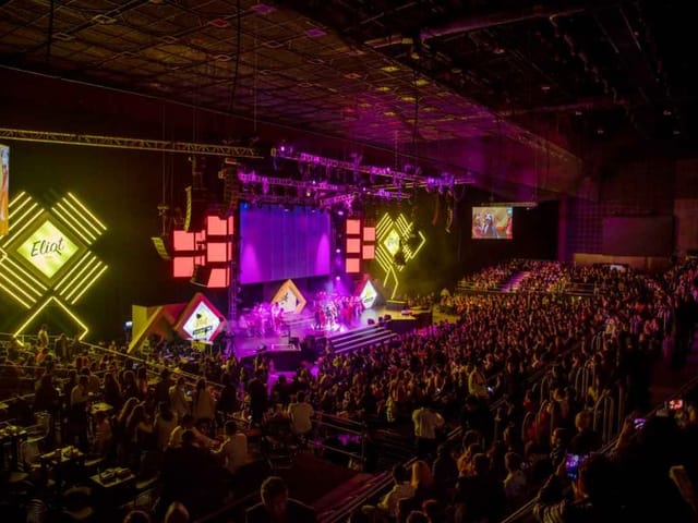 Branded stage design with dynamic LED lighting at a Frontón México corporate event or conference.