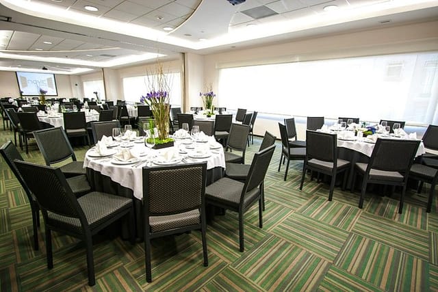 Hotel Novit banquet hall with round-table seating for corporate luncheons and gala events.