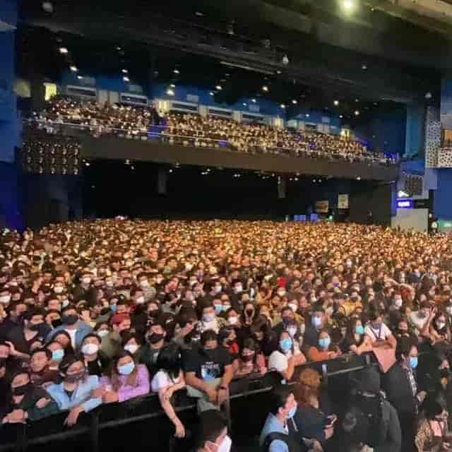 Crowded Pepsi Center ballroom concert with safety barricades, live music event venue.