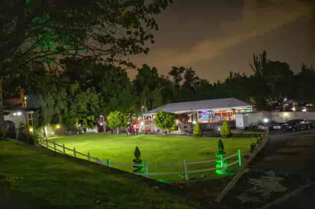 Outdoor function room at Finca La Gloria with lawn and open-air structure for wedding receptions.
