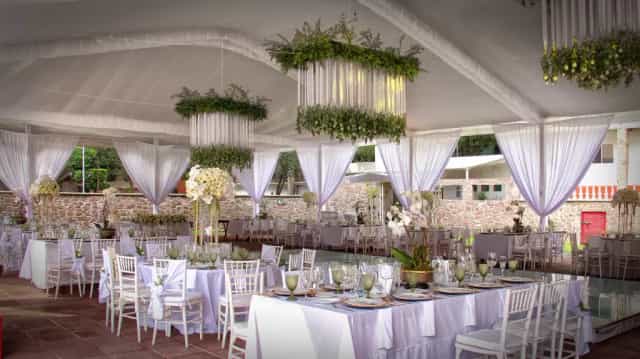 Finca La Gloria semi-outdoor event space with drapery and botanical chandeliers for wedding venue.