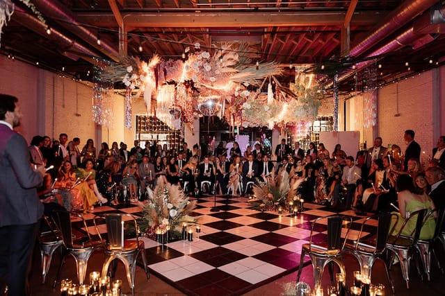 Skylight event space with floral installation and checkered dance floor for gala and corporate party.